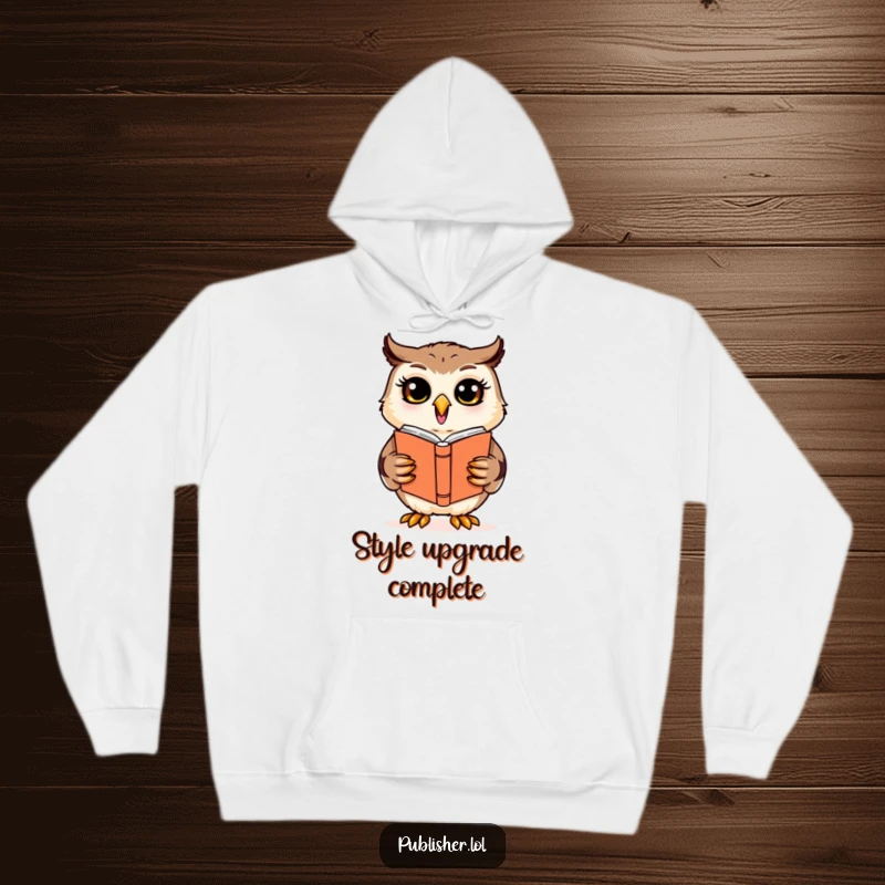 Funny cheerful owl character reviewing a book cover design, depicted on a warm hoodie, for the inspired designer.